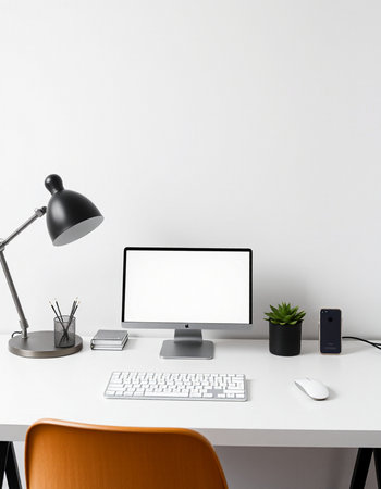 Modern workspace with computer, keyboard, mouse, lamp and other itemsの写真素材