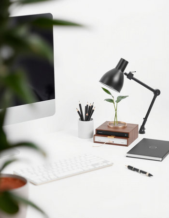 Minimal workspace with computer, stationery and plants on white backgroundの写真素材