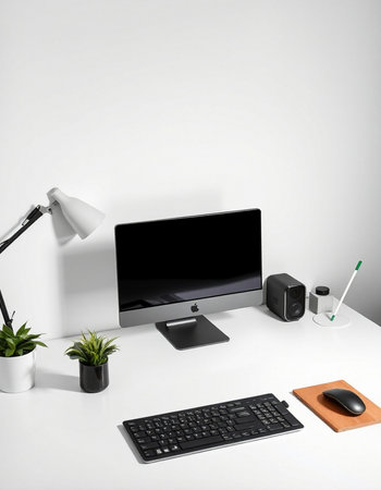 workplace with computer, keyboard, mouse, lamp and plant on table