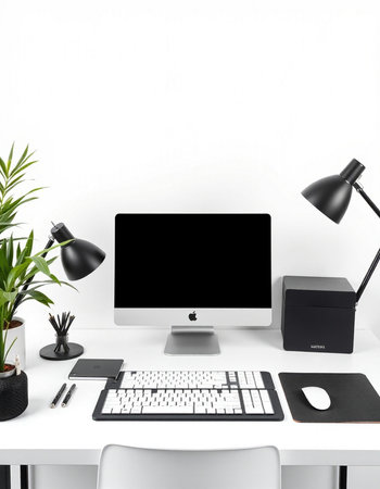 Modern workplace with computer, keyboard, mouse, lamp and plant on white table