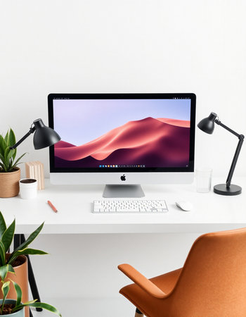 workplace with computer, table lamp and plant.