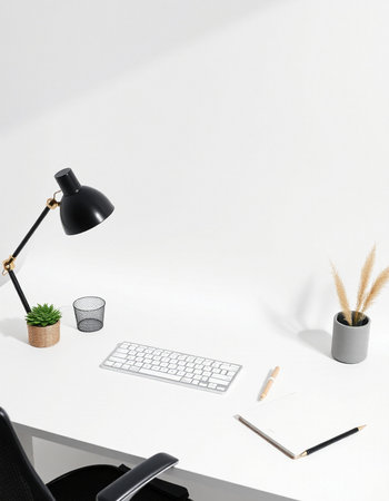 workplace with computer, stationery and plant on white wall backgroundの写真素材