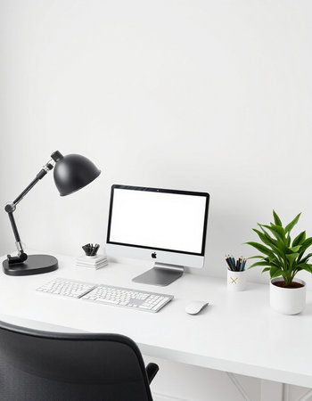workplace with computer, keyboard, mouse, lamp and plant on white table
