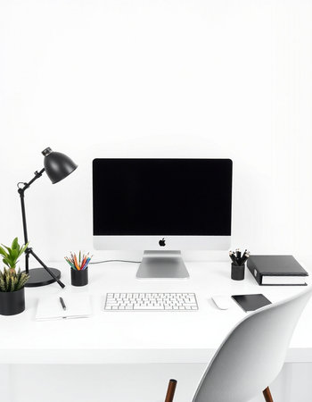 Modern workplace with computer, stationery and lamp on white wall backgroundの写真素材