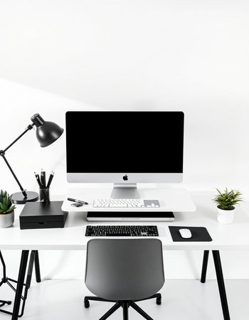 workplace with computer, lamp and other items on white wall background
