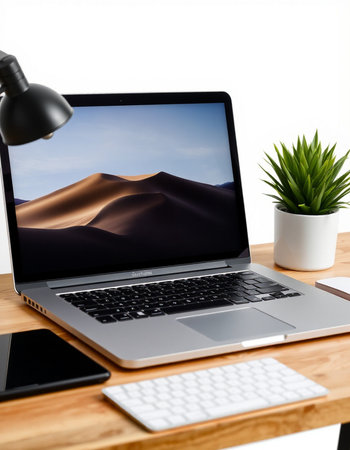 Close up of modern workplace with laptop, coffee cup and other items on wooden table