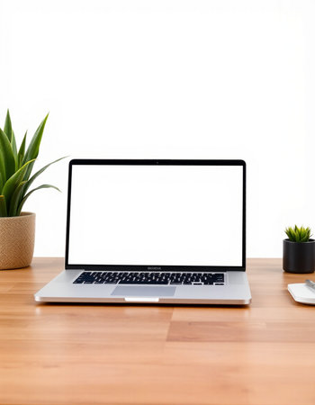Laptop with blank screen on wood table with white wall background.