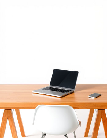 Laptop on wood table and white chair on white wall background.の写真素材