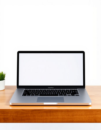 Laptop computer with blank screen on wood table and white wall background