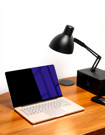 laptop computer and black lamp on wood table with white wall background