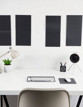 Modern office desk with blank black photo frames on the wall. Mock up