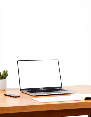 Laptop with blank screen on wood table and white wall background.