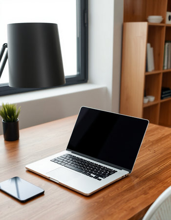 laptop with blank screen on wooden table in modern living room at homeの写真素材