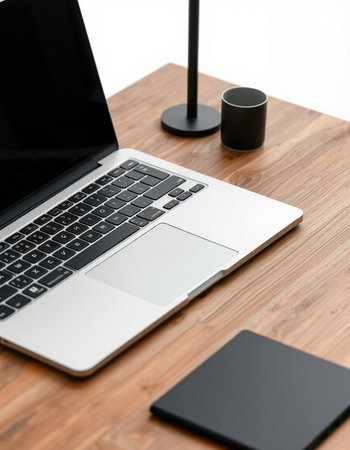 Laptop on wooden desk with black lamp and notebook. Workplace conceptの写真素材