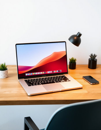 Modern workspace with laptop and coffee cup on wooden table and white wall backgroundの写真素材