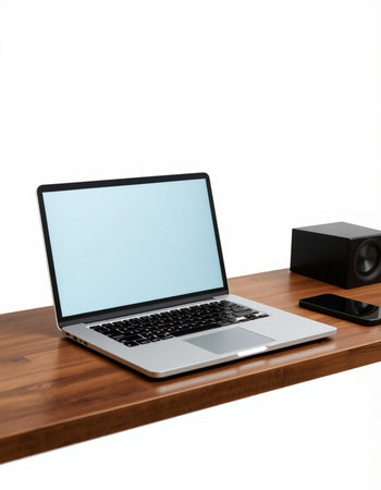 Laptop on a wooden table with a speaker on a white background