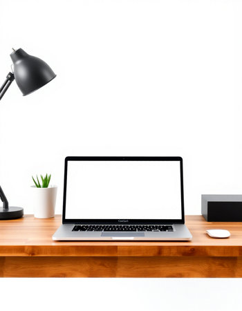 Laptop with blank screen on wooden table with lamp and decorations.