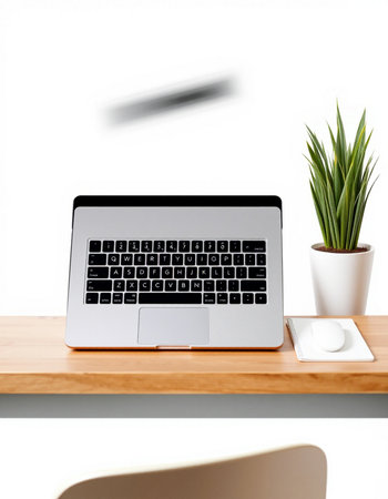 Laptop on a wooden table with a white wall in the background