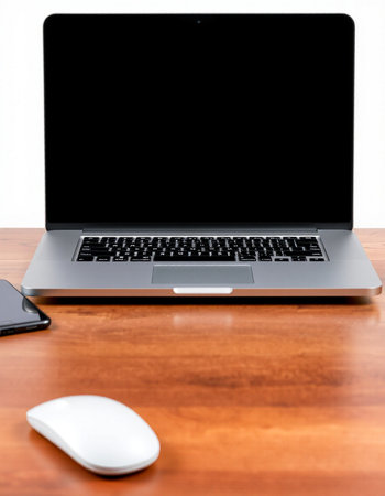 Laptop with black screen and mouse on wooden desk, work space
