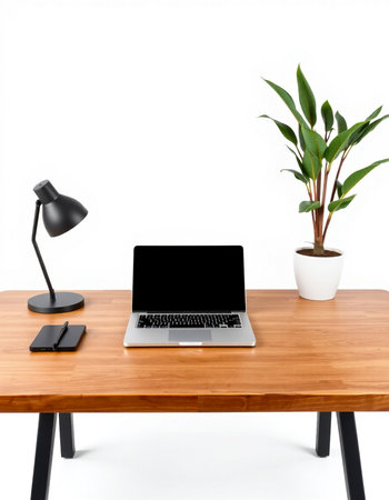 Laptop on wooden desk with black lamp and plant on white backgroundの写真素材