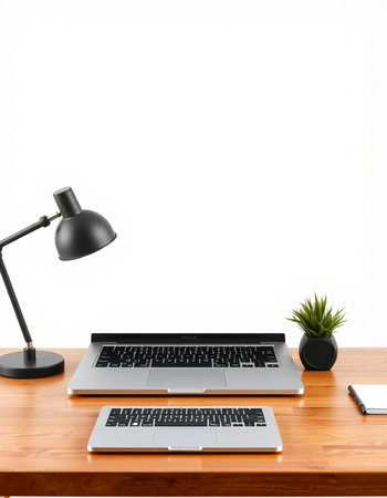 Laptop on a wooden table with a lamp and a plant.