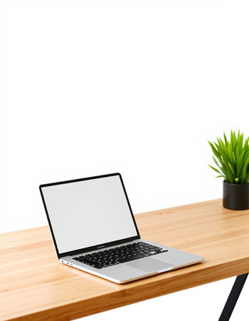 Laptop with blank screen on wooden table and white wall background.