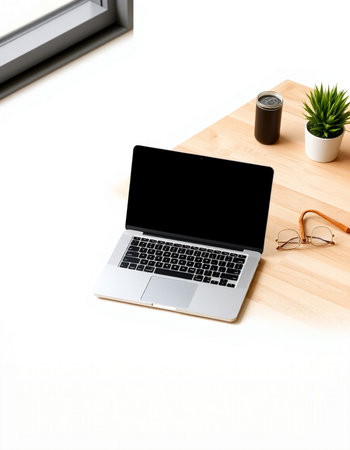 Laptop with blank screen on a wooden desk with glasses and a plant
