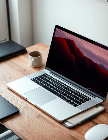 Laptop with blank screen and coffee cup on wooden table at homeの写真素材