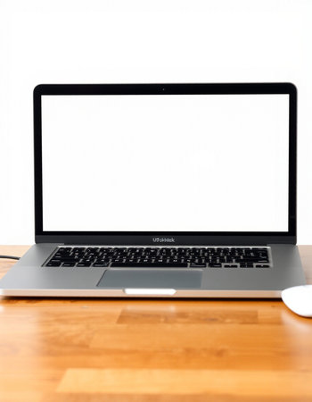 Laptop with blank screen on wooden table and white wall background.
