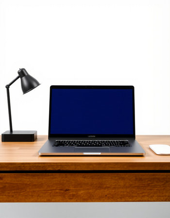 Laptop on a wooden table with a lamp on a white background