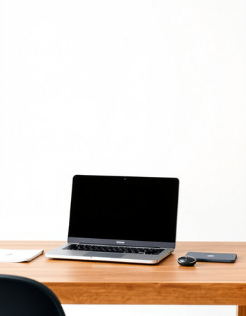 Laptop with blank screen on wooden table and white wall background.の写真素材