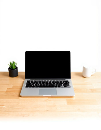 Laptop with blank screen on wooden desk and white wall background.