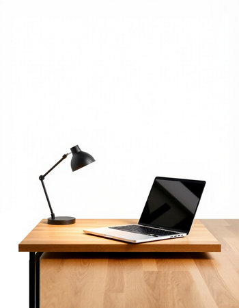 Laptop on a wooden table with a lamp on a white backgroundの写真素材