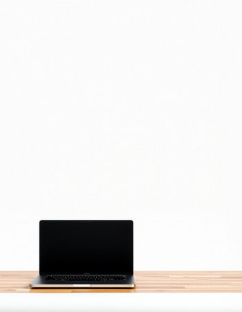 Laptop on a wooden desk with a white wall in the background