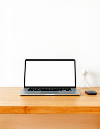 Laptop with blank screen on wooden table and white wall background.の写真素材