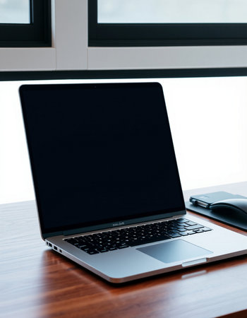 Laptop with blank screen on wooden table in office, stock photoの写真素材
