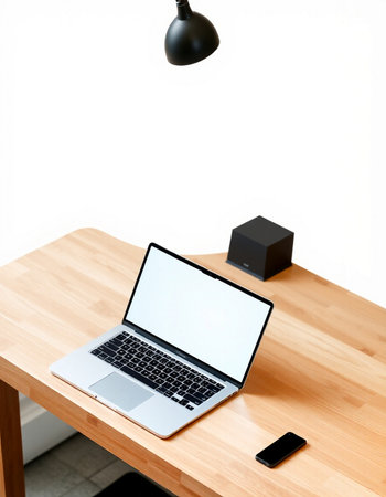 Laptop with blank screen on wooden table in office, stock photo