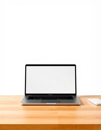 Laptop with blank screen on wood table and white wall background.