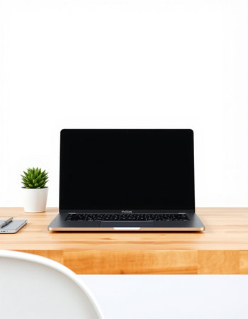 Laptop with blank screen on wooden table and white wall background.