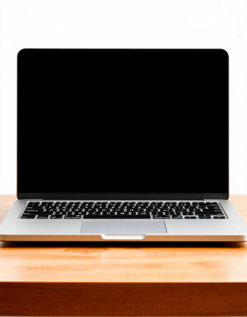 Laptop on a wooden table against a white background. View from above.