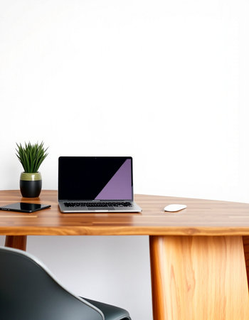 Laptop on a wooden desk with a white wall in the background
