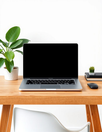 Laptop with blank screen on wooden table and white wall background.