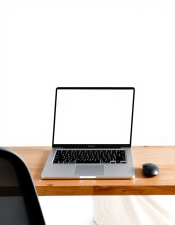 Laptop with blank screen on wooden desk and white wall background.