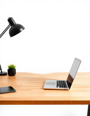 Laptop on a wooden desk with a lamp on a white background