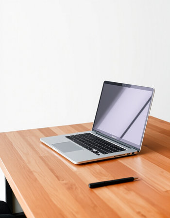 Laptop computer on the wooden table with white wall background, stock photo