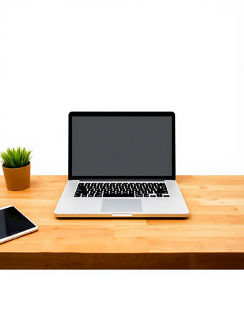 Laptop on wooden desk with smartphone and plant on white background.