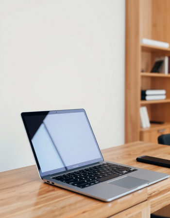 Laptop with blank screen on wooden table in office. Mock upの写真素材