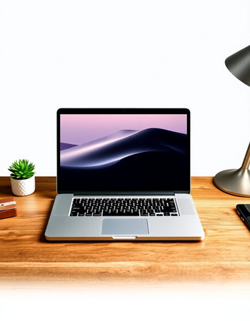 Laptop on a wooden table with a lamp and a plant.の写真素材