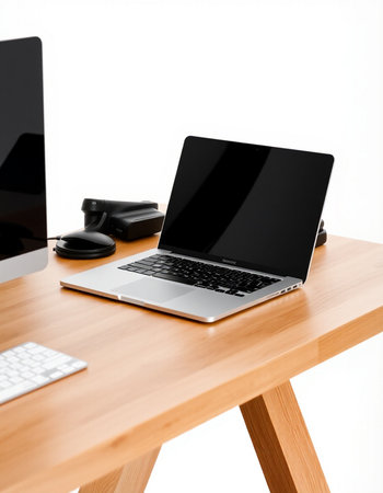 Laptop with black screen on wooden table isolated on white background.
