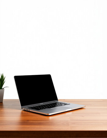 Laptop with blank screen on wooden desk and white wall background.
